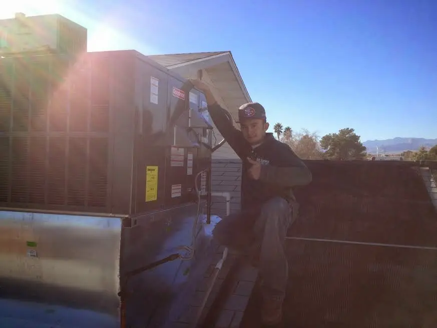 HVAC technician performing Air Duct Cleaning on a rooftop unit in Yorba Linda
